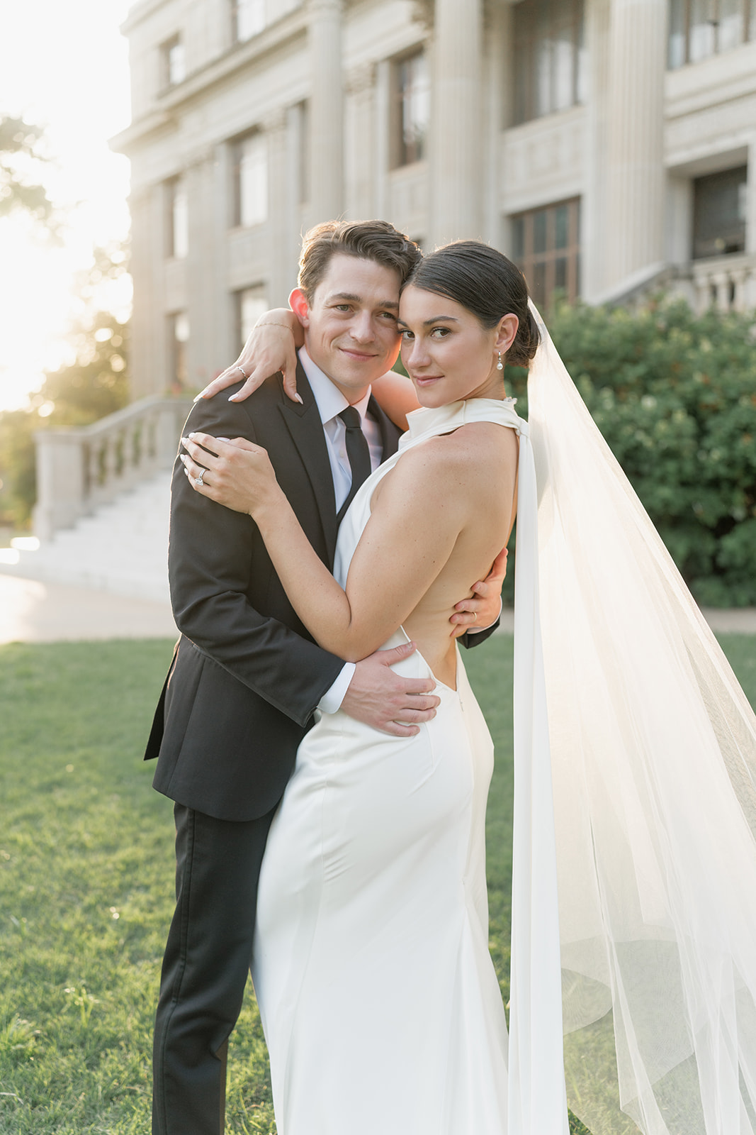 Back view of the bride’s open back satin gown as the couple descends the steps at the Oklahoma Hall of Fame, Oklahoma City wedding photography