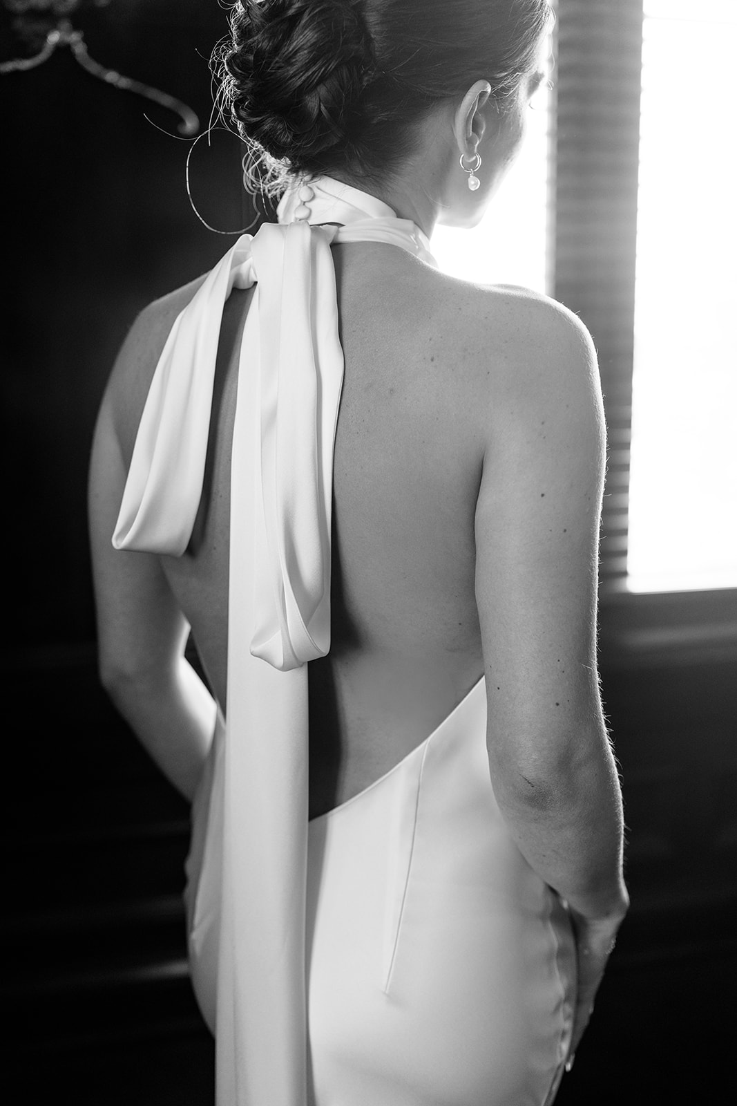 Groom holding the bride’s veil while she looks back at the camera, Oklahoma Hall of Fame wedding portraits in Oklahoma City