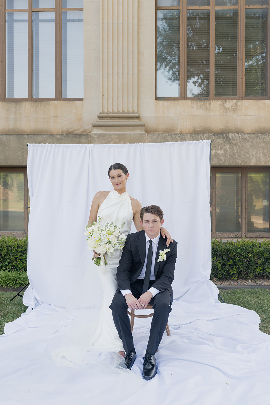 Editorial newlywed portrait with a white backdrop outside the Oklahoma Hall of Fame in Oklahoma City, Oklahoma wedding photographer